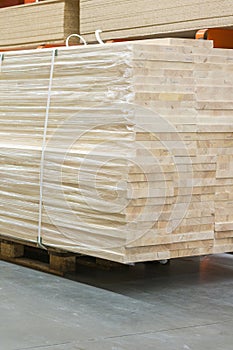 Pallet with boards in the hardware store. Packed boards in the building store. dry flat boards stacked together. building