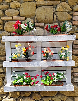 Pallet rebuilt into flower boxes with rustic wall