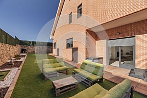 Pallet sofas with green Garden cushions in a single-family home with a light brown brick facade