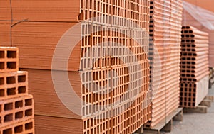 Pallets with stack of redbricks lying at warehouse