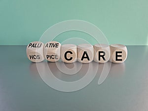 Palliative or hospice care symbol. Concept word Palliative care Hospice care on wooden cubes. Beautiful grey table blue background