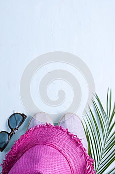 Palm branch, hat, shoes and sunglasses on a blue background, Summer vacation. Free space for text. Copy space. Flat lay