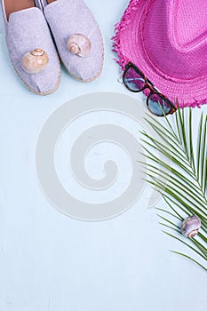 Palm branch, hat, shoes and sunglasses on a blue background, Summer vacation. Free space for text. Copy space. Flat lay