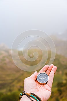 Palm with compass. Concept of figure out right direction. Haze valley and mountains in background. Santo Antao. Cape