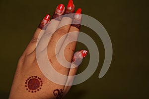 The palm of a girl with Mehandi design and nail poilish