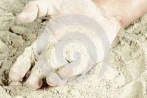 The palm of a hand covered with sand