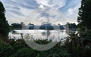 The Palm House and the lake in the Royal Botanic Gardens, Kew at dawn