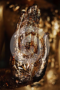 Palm of image of Buddha covering by gold leaf