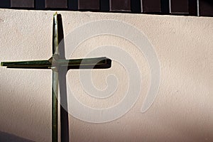 Palm leaf set cross to crucifix on the wall with the sunshine and shadow.