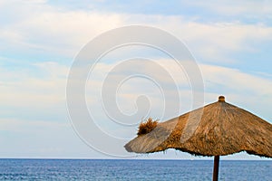Palm leaves umbrella and sea. Peaceful landscape of tropical island resort.