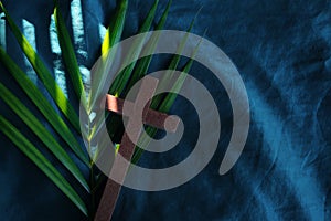Palm leaves with wooden crucifix cross flat lay composition. Palm sunday background.