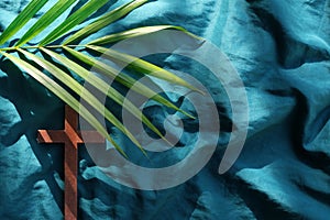 Palm leaves with wooden crucifix cross flat lay composition. Palm sunday background.