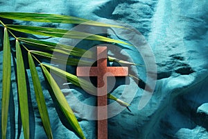 Palm leaves with wooden crucifix cross flat lay composition. Palm sunday background.