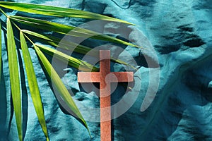 Palm leaves with wooden crucifix cross flat lay. Palm sunday celebration background.