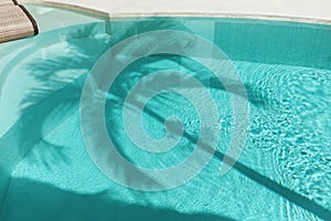 Palm Shadow On Water Surface. Swimming Pool With Silhouette Of Tropical Tree.