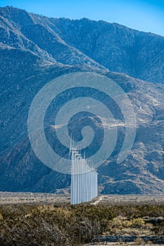 Palm Springs, California- Straight row of wind turbines on a shrubland