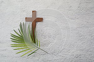 Palm sunday background. Cross and palm on grey background.