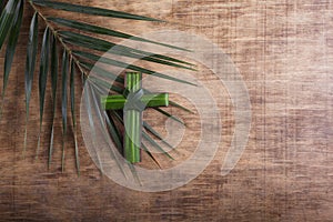 Palm sunday concept: Cross shape of palm branch on an antique wooden background