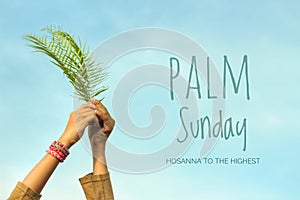 Palm Sunday quote - Hosanna to the highest. Fern or palm leaf in hands on bright and clear blue sky background.