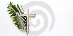 Palm Sunday. Wooden cross and palm leaf on white background with copy space.