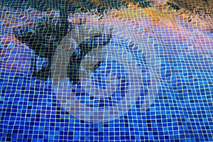 Palm tree reflecting in the blue pool water at sunset.