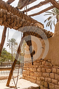 A palm tree trunk reel and leather bucket of the traditional Arab water well in Diriyah Park, Riyadh, Saudi Arabia photo