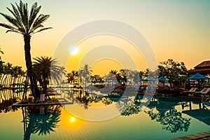 palm tree with umbrella chair pool in luxury hotel resort at sunrise times
