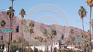 Palm trees in city near Los Angeles, street road sign, semaphore traffic lights.