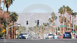 Palm trees, Palm Springs city street, road traffic, California USA. Cars driving