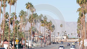 Palm trees, Palm Springs city street, road traffic, California USA. Cars driving