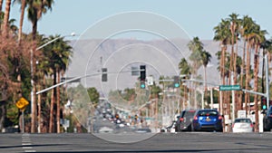 Palm trees, Palm Springs city street, road traffic, California USA. Cars driving