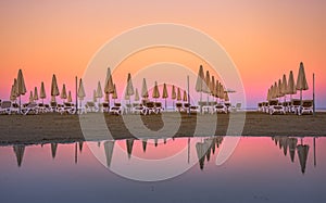 Palm trees and sunbeds at the sandy beach of Larnaca, Cyprus