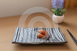 Palm weevil larvae in brown plate on the table. Foods are popular in Thailand and Asia. Eating edible insects concept. 