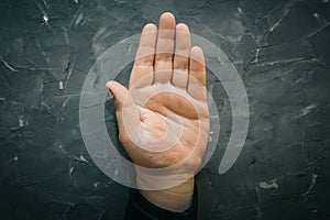 Palmistry concept. Male hand on gray table with open palm, chiromancy lines of fortune