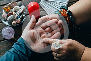 Palmistry fortune teller reads lines on man hand or palm to tell his future, top view