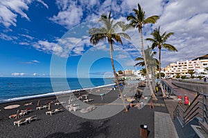 Palms  at beach with black lava sand at Puerto Naos in La Palma Island, Canary Island, Spain