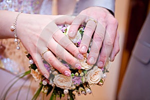 The palms of the bride and groom on the bouquet