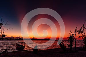 Palms and sunset or sunrise at tropical beach with sea in Gili island