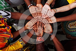 Palms up hands of happy group of multinational African, latin american and european people which stay together in circle