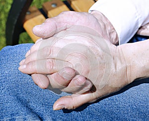 Palms of wrinkled hands of an elderly holding of man female hand