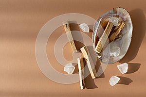 Palo Santo sticks with clear natural crystals in sea shell. Meditation, aromatherapy, mental health and ritual concept.