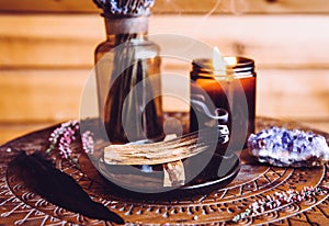 Palo Santo wood known as oily aromatic holy wood sticks smouldering on plate in home living room cleansing negative energy concept