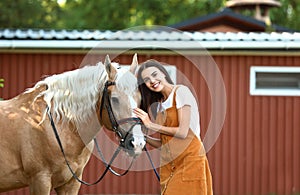 Palomino horse in bridle and young woman