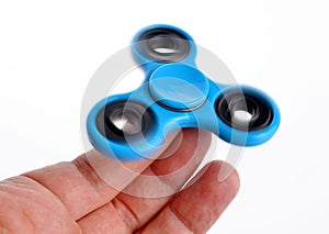 Palying with a blue Fidget Spinner.