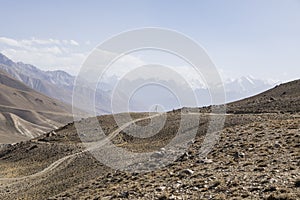 Pamir Highway in the desert landscape of the Pamir Mountains in Tajikistan. Afghanistan is on the left photo