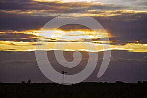 Pampas windmill landscape at sunsetin storm, La Pampa photo