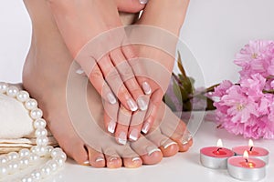 Pampering Perfection: French Nail Polish on Beautiful Female Feet and Hands in Spa Salon