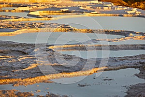 Pamukkale white mineral limestone natural pool at sunset. Turkey