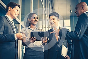 Pan Asian and Caucasian business team looking at tablet computer