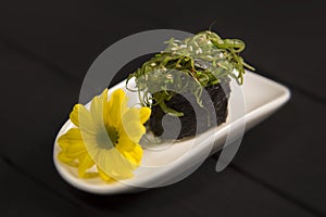 Pan Asian Chuka seaweed gunkan sushi with Hiyashi wakame and sesames on white plate. Sushi restaurant menu close up.